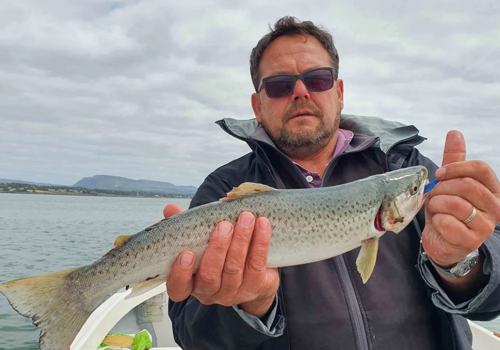 Man holding a sea trout with both hands